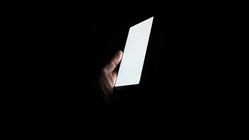 夜の暗がりで光るスマートフォン