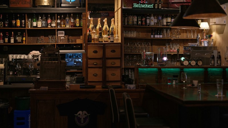 お酒の瓶が並ぶ薄暗いバーのカウンター